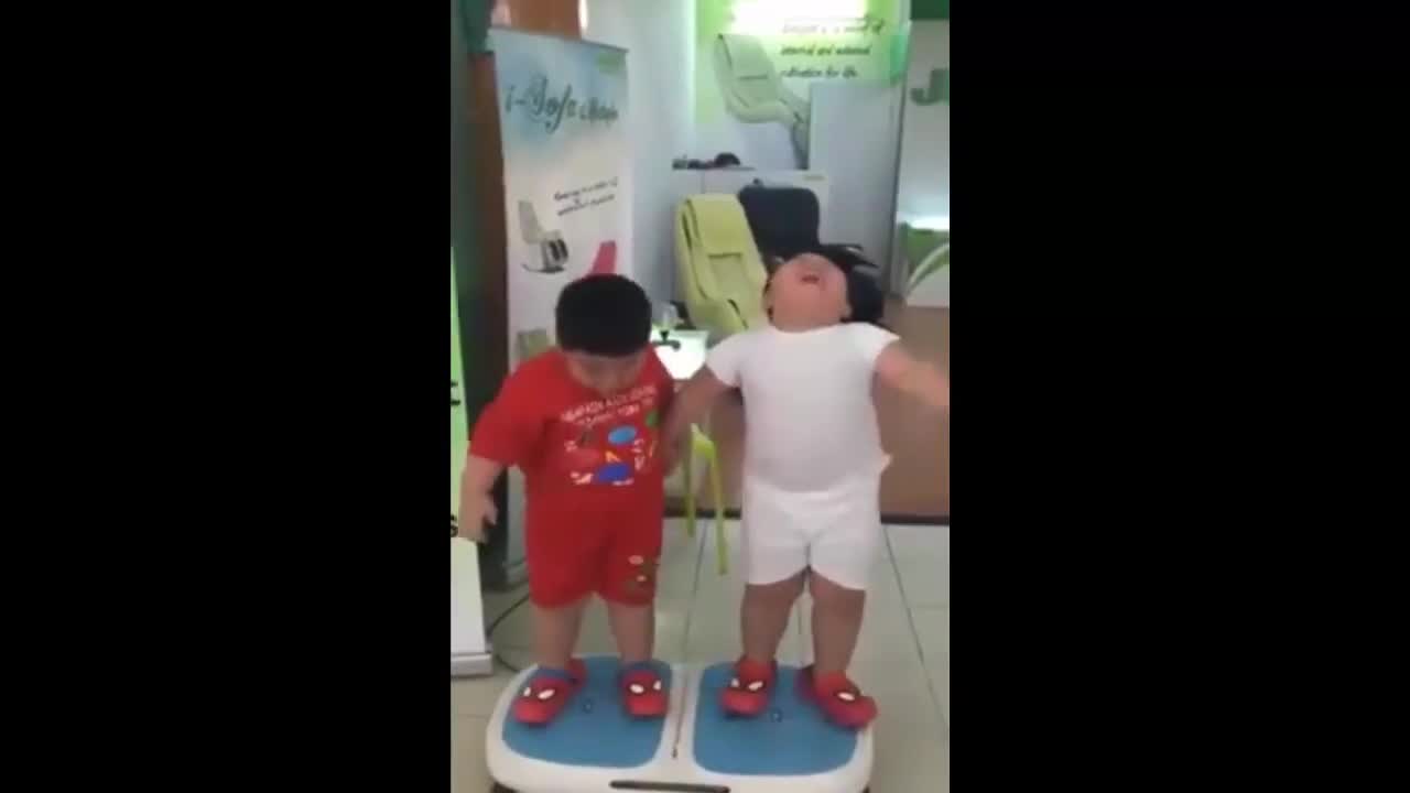 Cười nghiêng ngả với 2 bé mập đứng trên máy rung lắc