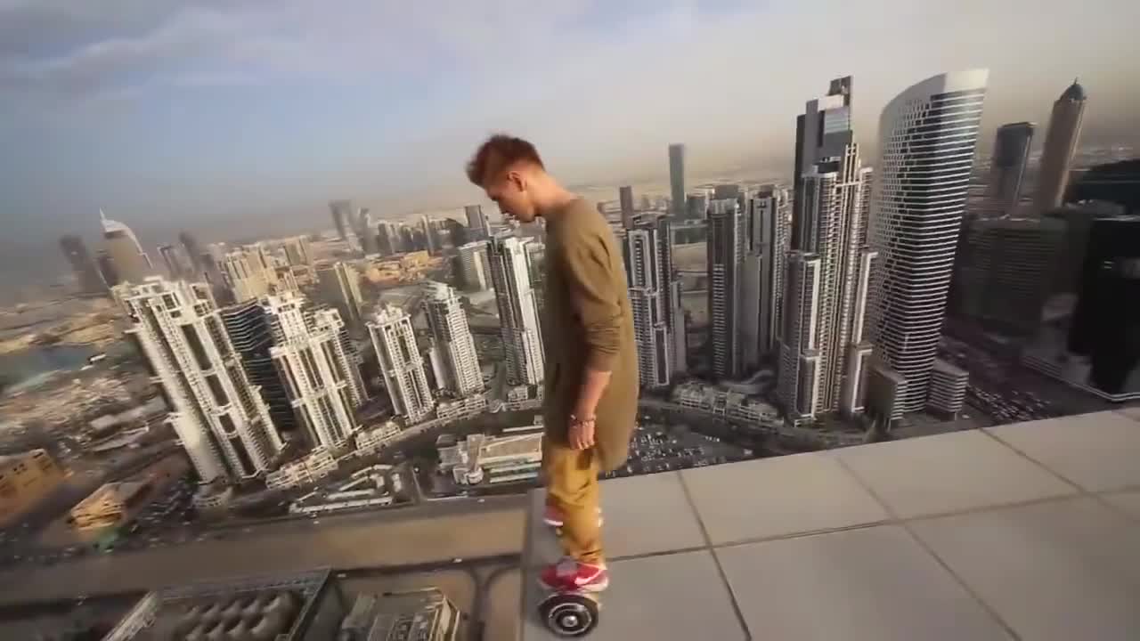 Thanh niên trượt ván trên nóc nhà cao tầng