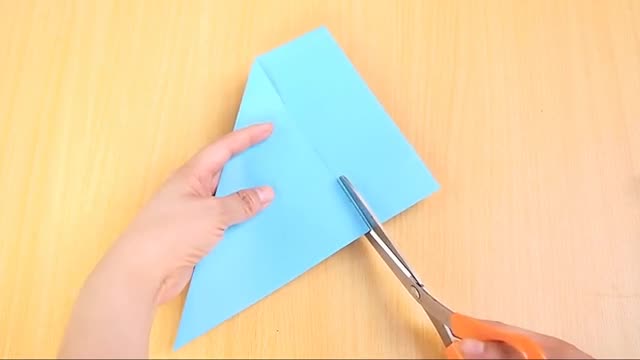 Dùng kéo cắt đi phần thừa của tờ giấy