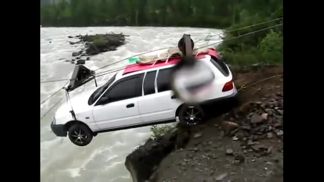 Ô tô đu cáp treo vượt sông dữ