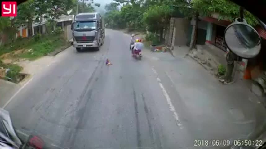 Tài xế hú vía khi bé trai băng qua đầu xe container