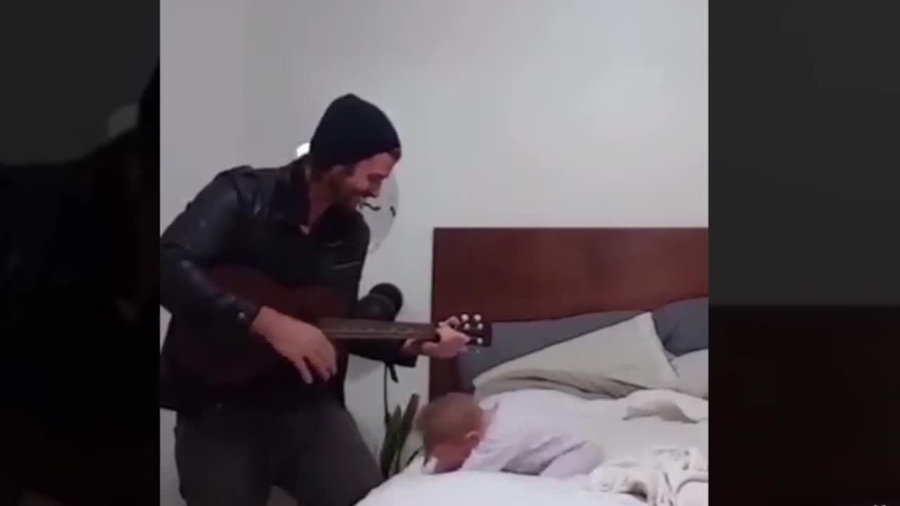 Bé gái phấn khích khi nghe ông bố vừa đàn vừa hát