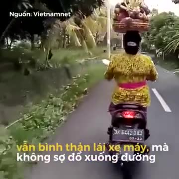 Người phụ nữ đội giỏ trái cây trên đầu, chạy bon bon trên đường