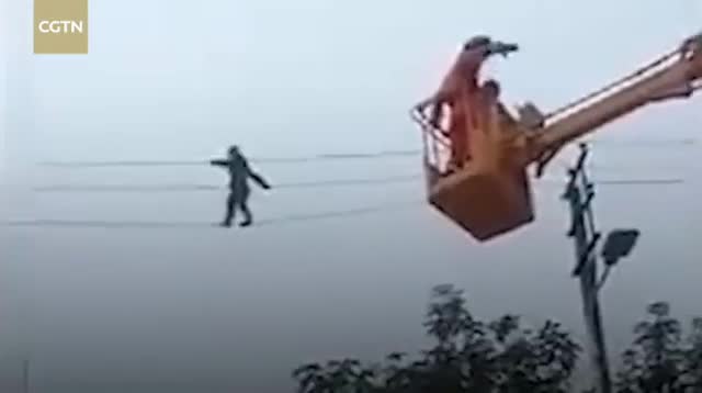 Người đàn ông say rượu hồn nhiên đi trên dây điện cao thế