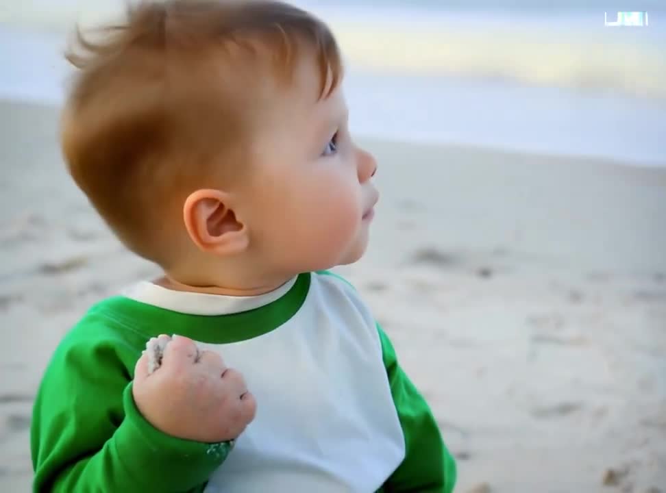 Em bé nắm tay cát